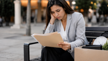 woman on park bench laid off from work